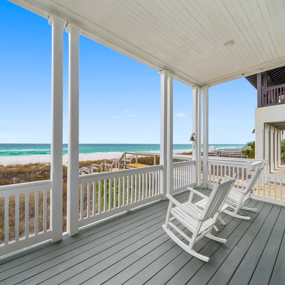 Sway in your rocking chair while turquoise waves dance before you on this covered porch—your perfect perch for morning coffee and endless ocean views.