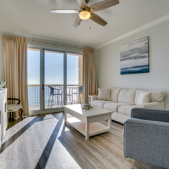Sink into plush sofas in your bright living room, where ocean views through sliding doors create a serene backdrop for relaxation.