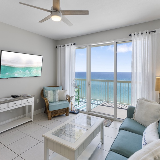 Relax in your bright oceanfront living room with stunning sea views from floor-to-ceiling windows and comfortable coastal decor.