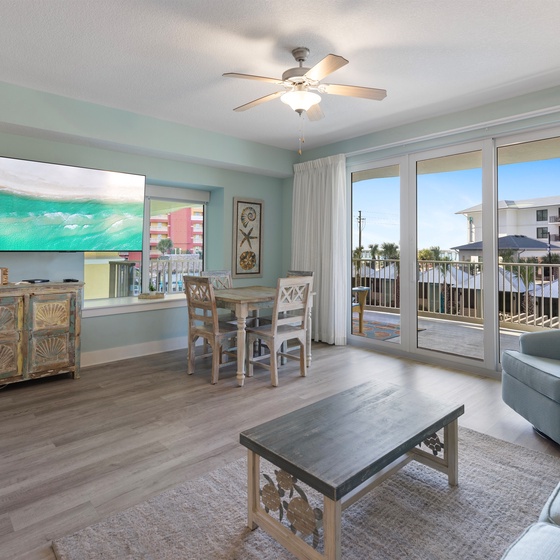 Relax in your coastal-themed living space with soft sage walls, comfy seating, and a private balcony perfect for morning coffee.