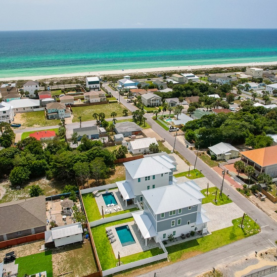 Coastal beachfront community with turquoise waters and white sand beaches just steps away from residential neighborhoods.