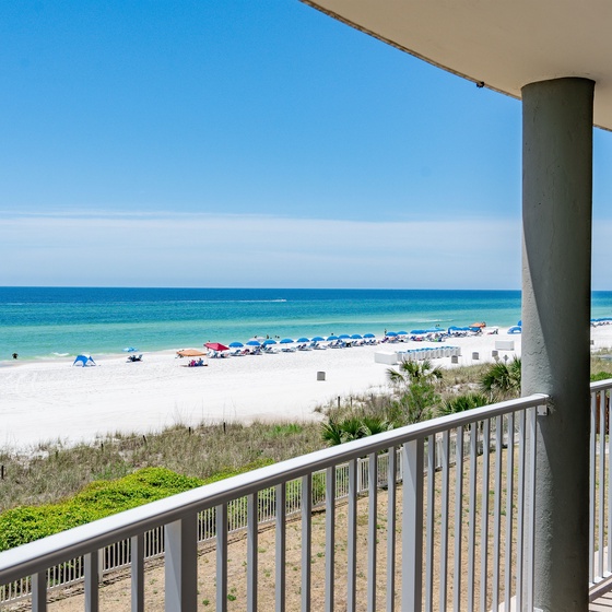 Stunning beachfront balcony overlooking pristine white sand and turquoise waters where you can watch beach activities unfold.