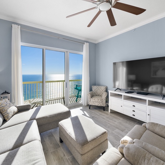 Relax in your bright oceanfront living room with stunning sea views and modern comforts like a big-screen TV and ceiling fan.