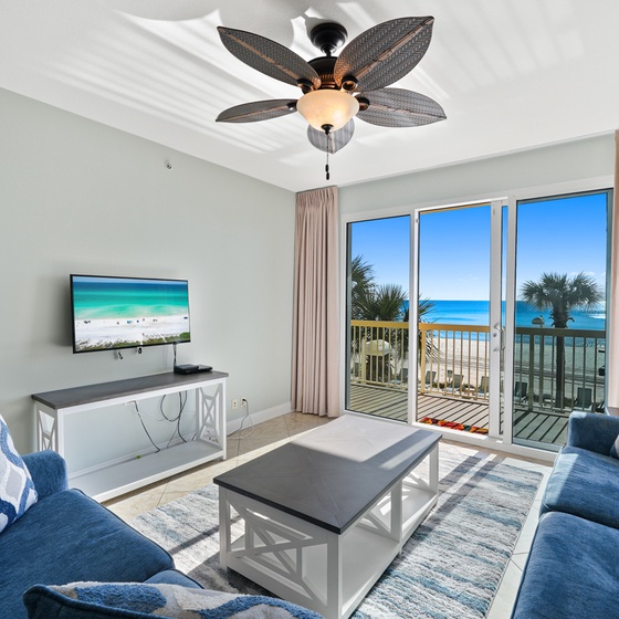 Sink into plush blue sofas while ocean views fill your windows and gentle ceiling fan keeps you cool.