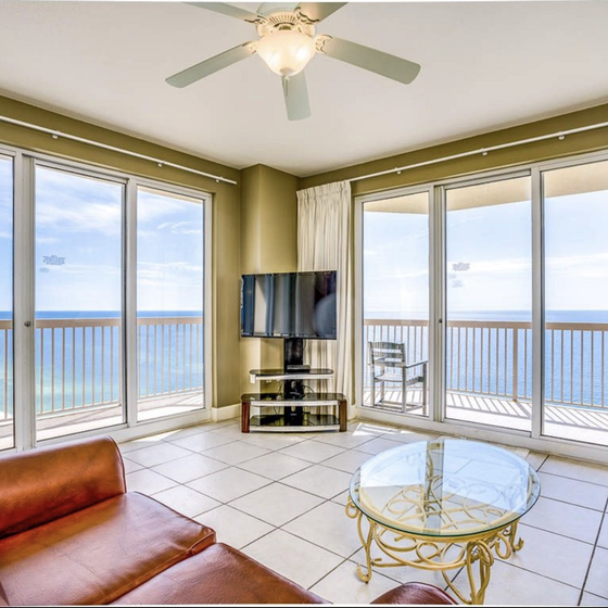 Unwind in this sun-drenched living room where floor-to-ceiling windows frame endless ocean views, creating your perfect beachfront sanctuary.