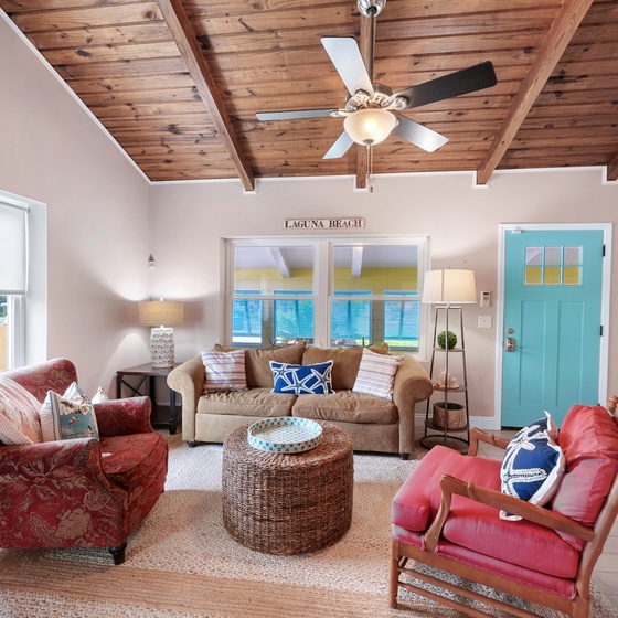 Relax in your coastal living room with beautiful wood ceilings, comfortable seating, and bright beach-inspired decor that instantly puts you in vacation mode.