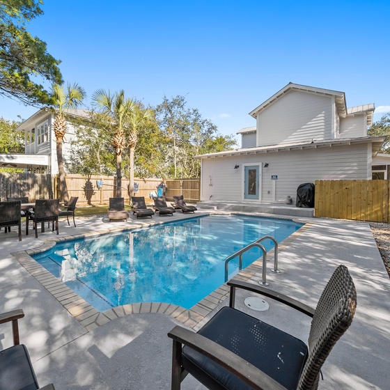 Your private oasis awaits with sparkling pool, sun-dappled loungers, and peaceful outdoor dining under swaying palms.