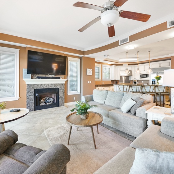 Sink into plush seating by your cozy fireplace, where warm earth tones and modern comfort create your perfect home base.
