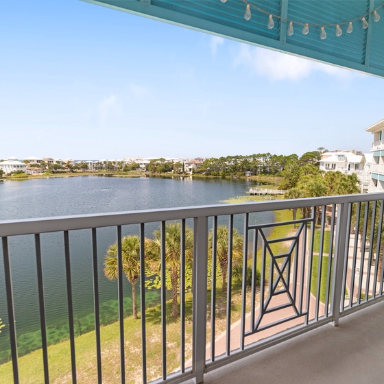 Serene lake views and gentle breezes await you on your private balcony, framed by palm trees and lush coastal scenery. A peaceful retreat to start your mornings or unwind after exploring.