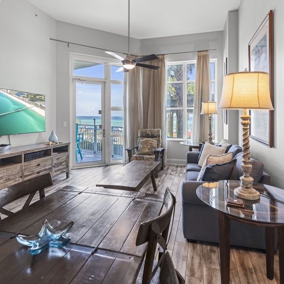 Relax in your bright living space with stunning ocean views through floor-to-ceiling windows and coastal decor throughout.