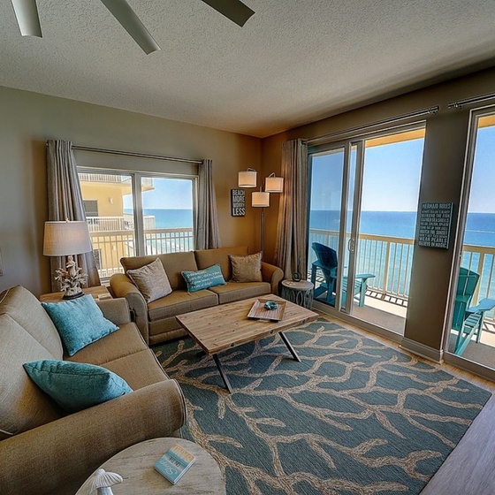Sink into plush seating while endless ocean views fill your horizon through floor-to-ceiling windows in this bright, coastal-inspired living room.