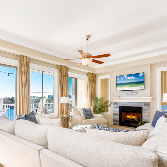 Unwind in your bright living room with plush seating, cozy fireplace, and gorgeous water views through floor-to-ceiling windows.