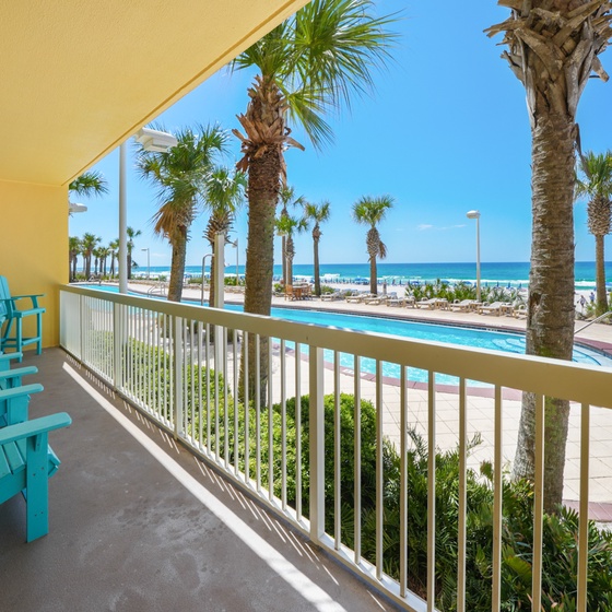 Relax in your turquoise chairs while soaking up stunning ocean views from your private balcony overlooking tropical palms and pristine beach.