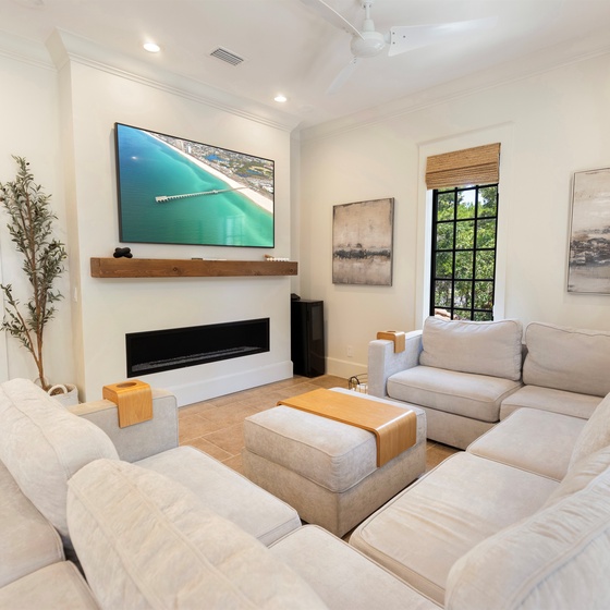 Sink into plush white sofas facing your modern fireplace and large TV—perfect for cozy evenings after exploring nearby attractions.