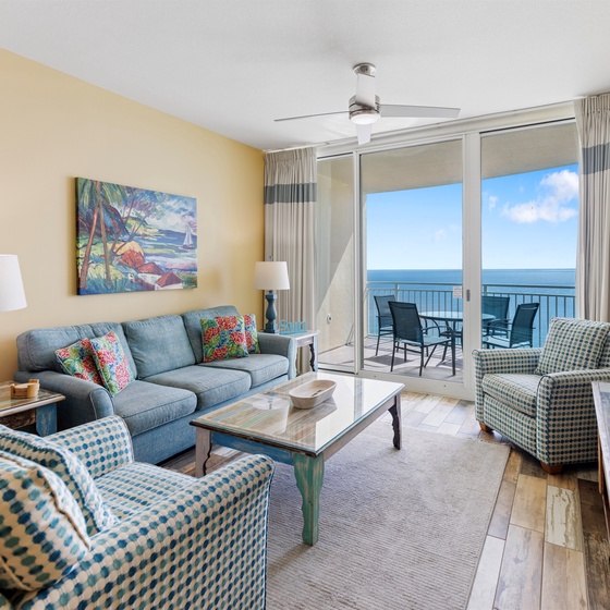 Unwind in your bright oceanfront living room with panoramic sea views through floor-to-ceiling windows and comfortable seating.