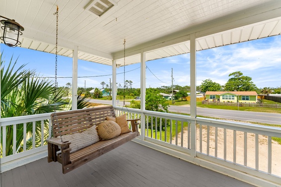 A screened-in porch offers a relaxing spot to unwind. Settle into the swing and enjoy the peaceful neighborhood view framed by lush greenery.