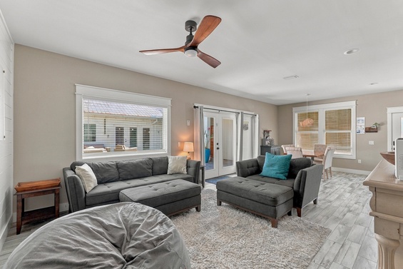 Settle into this bright, airy living room where natural light pours through large windows and a ceiling fan keeps you comfortable year-round.