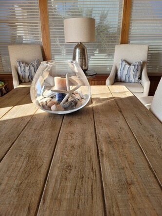 Gather around this welcoming dining table where sunlight streams through windows, perfect for morning coffee or evening meals with loved ones.