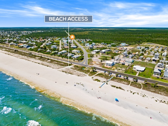 Aerial view of a beachside neighborhood with convenient access to pristine sandy shores and turquoise waters, surrounded by coastal homes and lush greenery.