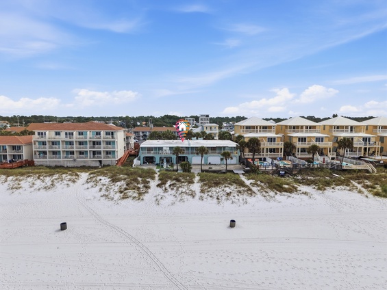 Beachfront vacation property with direct sandy beach access, swimming pool, and multiple buildings offering coastal accommodations in a relaxed neighborhood setting.