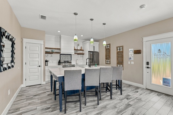 Gather around the spacious kitchen island where modern style meets coastal charm. Pendant lights illuminate your culinary space, and thoughtful details throughout invite connection.
