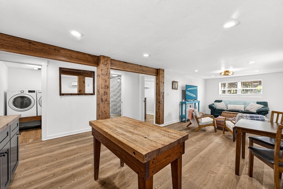 Relax in your spacious open living area, featuring warm wood beams, modern conveniences, and a cozy seating nook where you can unwind after exploring.