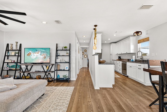 Step into a bright, open space where your vacation days unfold seamlessly. The fully equipped kitchen invites you to prepare meals together while warm wood floors guide you from lounging to dining effortlessly.