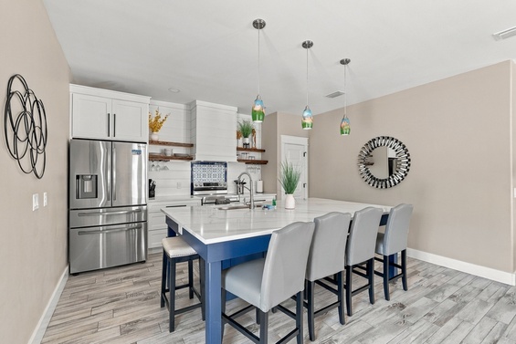 Gather around the expansive island in your fully-equipped kitchen, where modern appliances and elegant pendant lighting set the scene for memorable meals together.