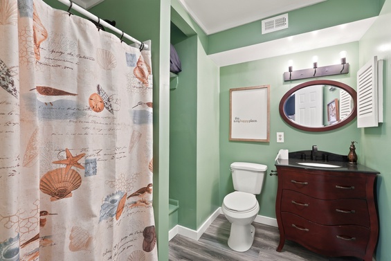 Step into your coastal-inspired bathroom with soothing mint-green walls, rich wood vanity, and elegant oval mirror—a refreshing escape where you'll start and end each day feeling renewed.