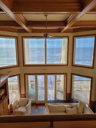 Unwind in your light-filled living room with soaring ceilings and panoramic ocean views that frame the horizon—your perfect spot for morning coffee or evening relaxation.