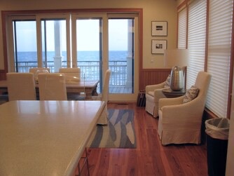 Your peaceful retreat opens to a stunning oceanfront view. Soft seating invites you to unwind, while large glass doors frame the endless blue horizon just steps away.
