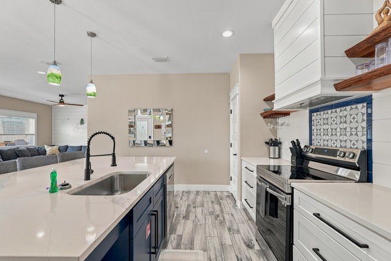 Gather around your sleek island and cook like a pro in this bright, modern kitchen—complete with stylish backsplash and open shelves that keep your favorites within easy reach.