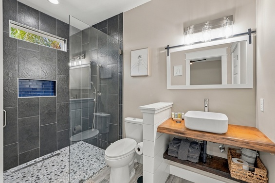Refresh after a day of adventure in your stylish bathroom with a spacious walk-in shower, sleek vessel sink, and modern finishes throughout. The sliding barn door mirror and terrazzo-style tile add a thoughtful, contemporary touch.