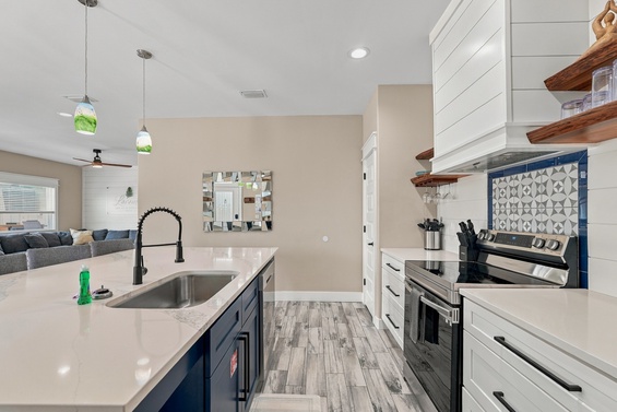 Your bright, modern kitchen invites you to gather and cook with gleaming countertops, stylish tile backsplash, and rustic open shelving. A spacious island and cozy seating make it easy to savor every moment.