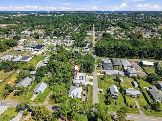 Aerial view of the property nestled in a peaceful, tree-lined neighborhood with nearby city access.