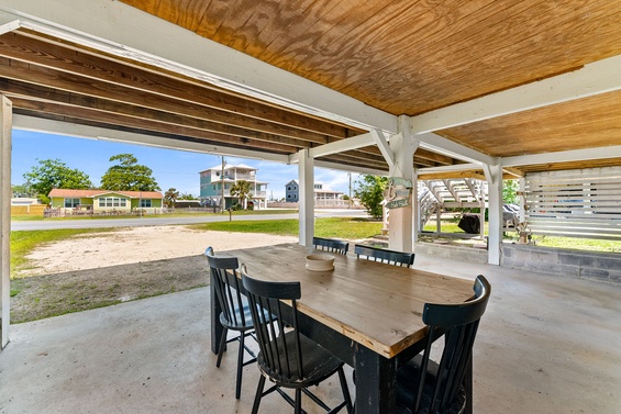 Gather around this inviting outdoor dining space where you can enjoy meals under a shaded wood-beamed pavilion with views of the surrounding neighborhood.