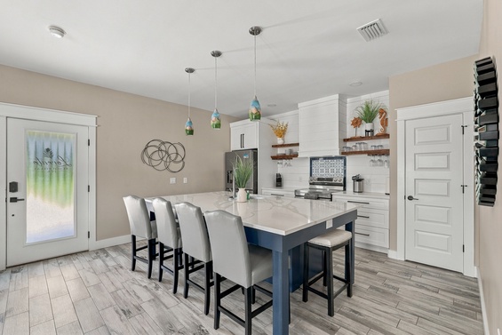 Gather around the spacious kitchen island for meals and conversation. Bright pendant lighting, marble countertops, and modern appliances create a welcoming space where your group can cook and connect together.
