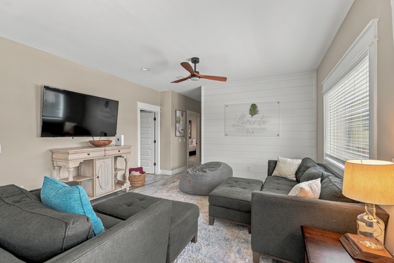 Settle into plush seating and unwind under gentle ceiling fan breezes. Bright windows and coastal accents create your cozy retreat for movie nights and morning coffee.