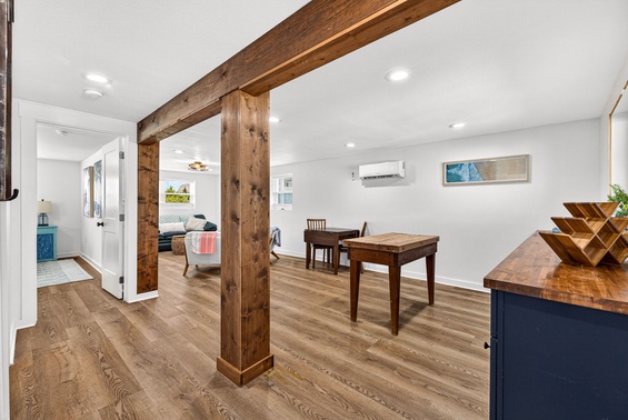 Warm wood beams frame your open living and dining space, where you'll find modern comfort meets rustic charm. Gather around the table, relax in the cozy seating, and enjoy central air conditioning for perfect temperature control year-round.