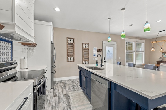 Step into a bright, modern kitchen with stunning marble countertops and coastal-inspired pendant lights. Gather around the spacious island or prepare meals with top-tier appliances—your home away from home awaits.