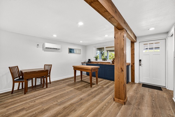 Gather around the warm wood dining table in this inviting space, where rustic timber beams meet modern comfort. Natural light flows in, setting the perfect scene for your morning coffee or evening meals.