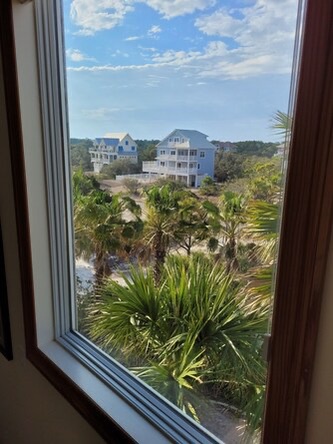 Look out over lush tropical greenery and neighboring properties from your window—a peaceful slice of coastal living just steps from the beach.