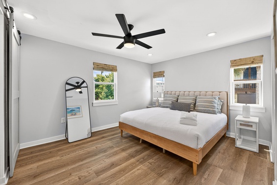 Relax in your serene bedroom with crisp linens, natural light streaming through bamboo shades, and a modern ceiling fan keeping you cool throughout your stay.
