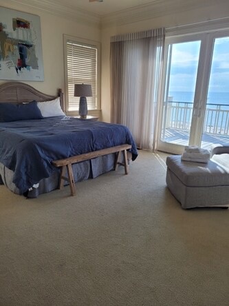 Wake up to stunning blue waters framed by your private balcony. This serene bedroom invites you to unwind in plush bedding while gentle ocean breezes and endless views create your perfect coastal escape.