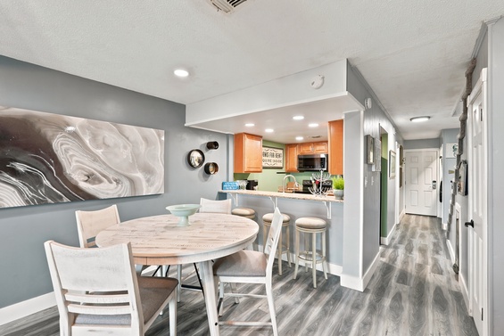 Picture yourself sharing meals at this stylish dining table, with the open kitchen just steps away. The modern décor and warm lighting create a welcoming space where your group can gather and relax together.