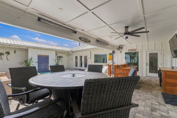 Gather around the spacious outdoor dining table under the covered patio, where ceiling fans and heaters ensure year-round comfort. Your private courtyard setting invites effortless entertaining and relaxed meals in the open air.