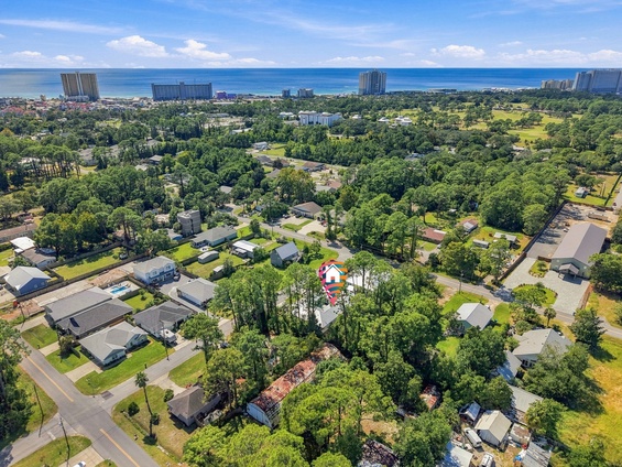 Aerial view of the property's location nestled among lush greenery in a peaceful residential neighborhood, with the sparkling Gulf Coast just moments away.