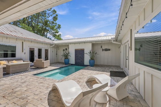 This private courtyard features a sparkling pool surrounded by comfortable lounge seating and modern outdoor furniture—your perfect spot for sunny relaxation and poolside lounging.