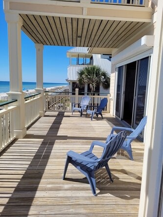 Kick back in coastal Adirondack chairs with unobstructed ocean views. Feel the sea breeze on your private deck with pergola shade and direct beach access just steps away.