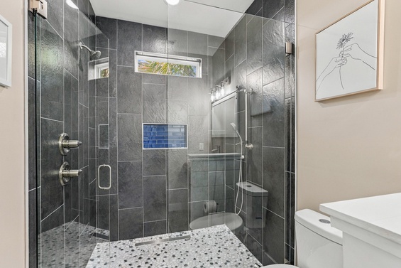 Step into your sleek, spa-inspired shower with dual controls, a handheld sprayer, and gorgeous dark tile—your refreshing retreat after every adventure.